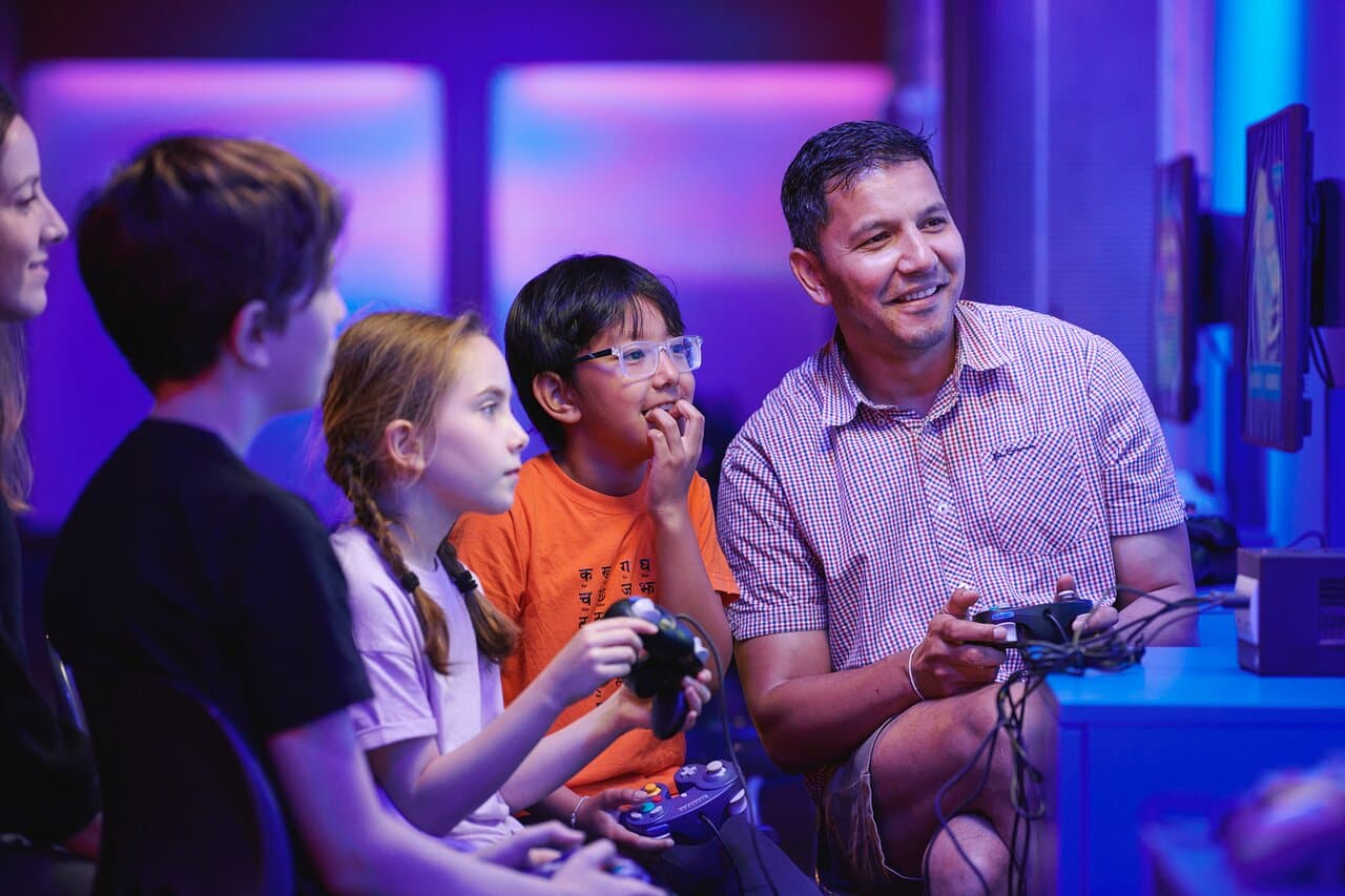 Families and friends enjoying a 4-player game in Power Up, the Science Museum’s hands-on gaming experience.  © Science Museum Group 